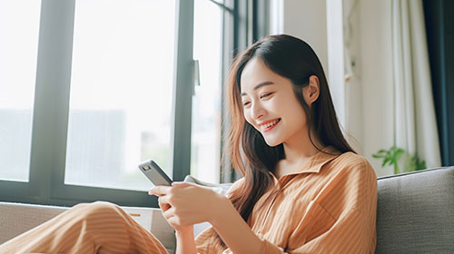 スマホを見る若い女性の写真