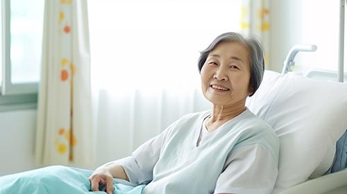 病室で微笑む高齢の女性