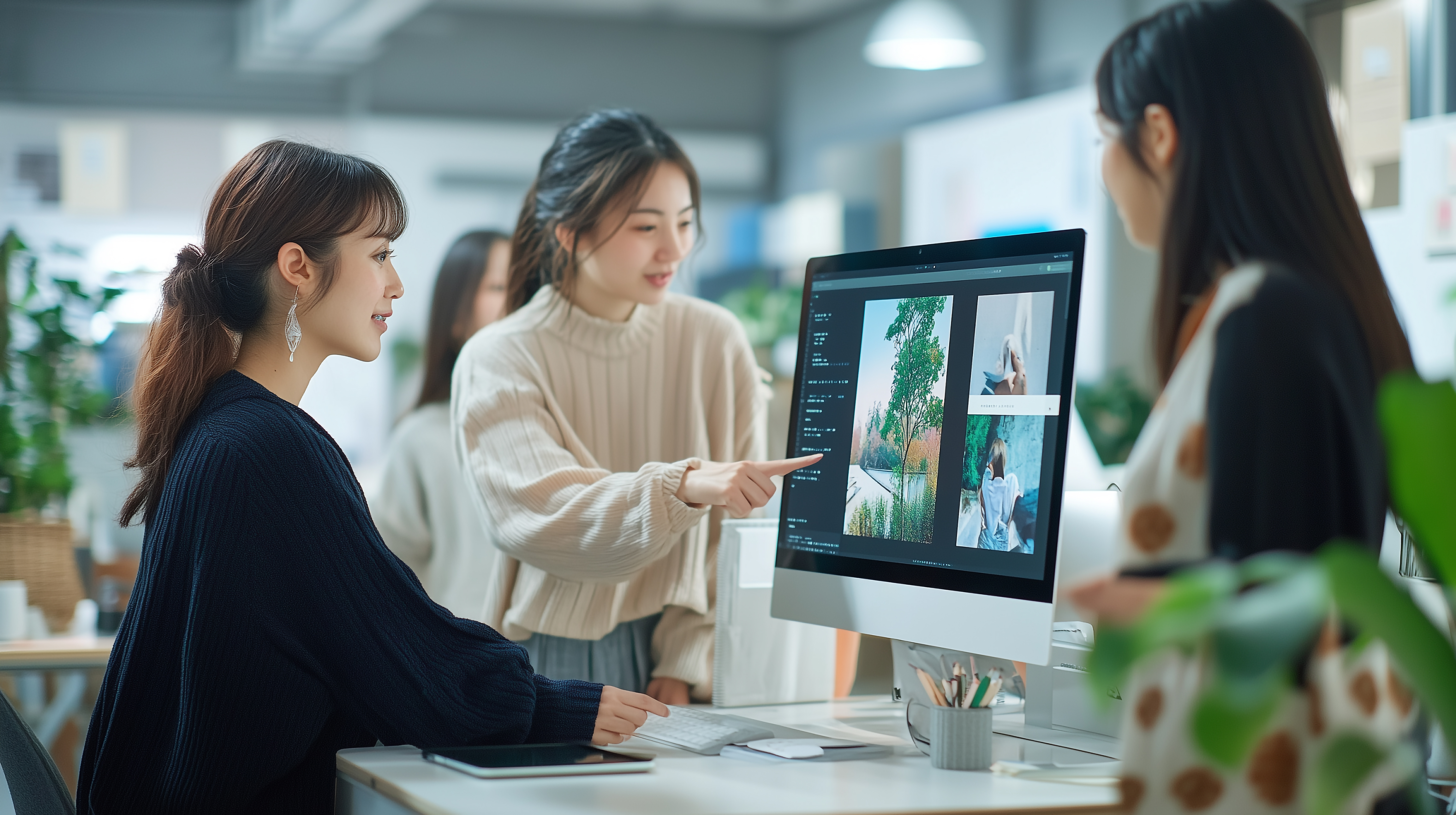 パソコンの前で打ち合わせ中の女性社員たち