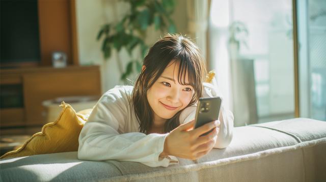 ソファーでスマホをみている若い女性